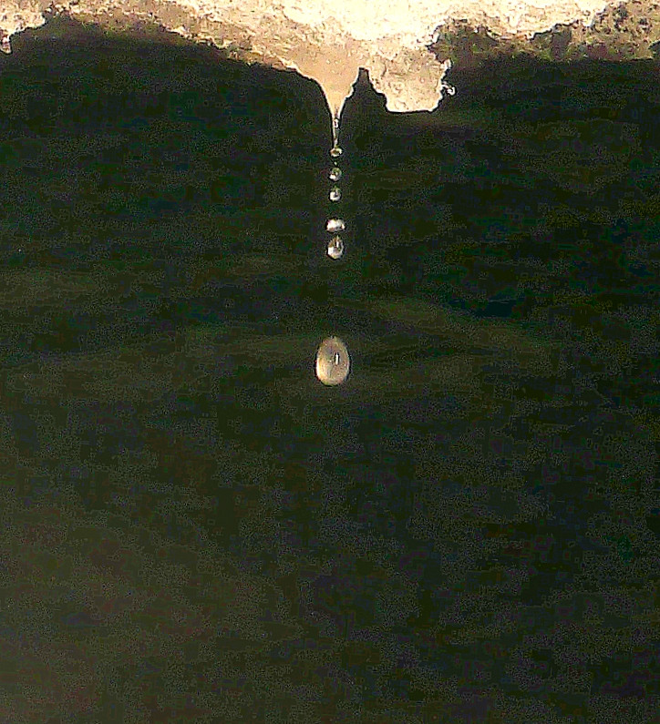 Goutte d'eau chutant à l'envers sur le sol d'une grotte