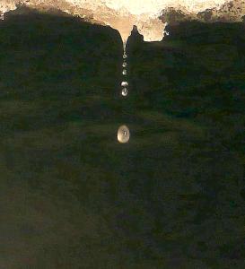 Goutte d'eau chutant à l'envers sur le sol d'une grotte